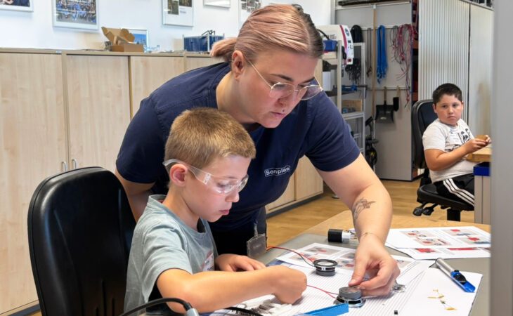Pictured are a woman and a young boy. The woman is helping the boy