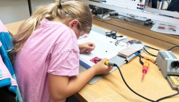 Pictured is a young girl working on her kit