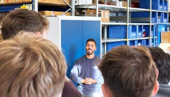 Pictured is an employee who is telling the students more about his job.