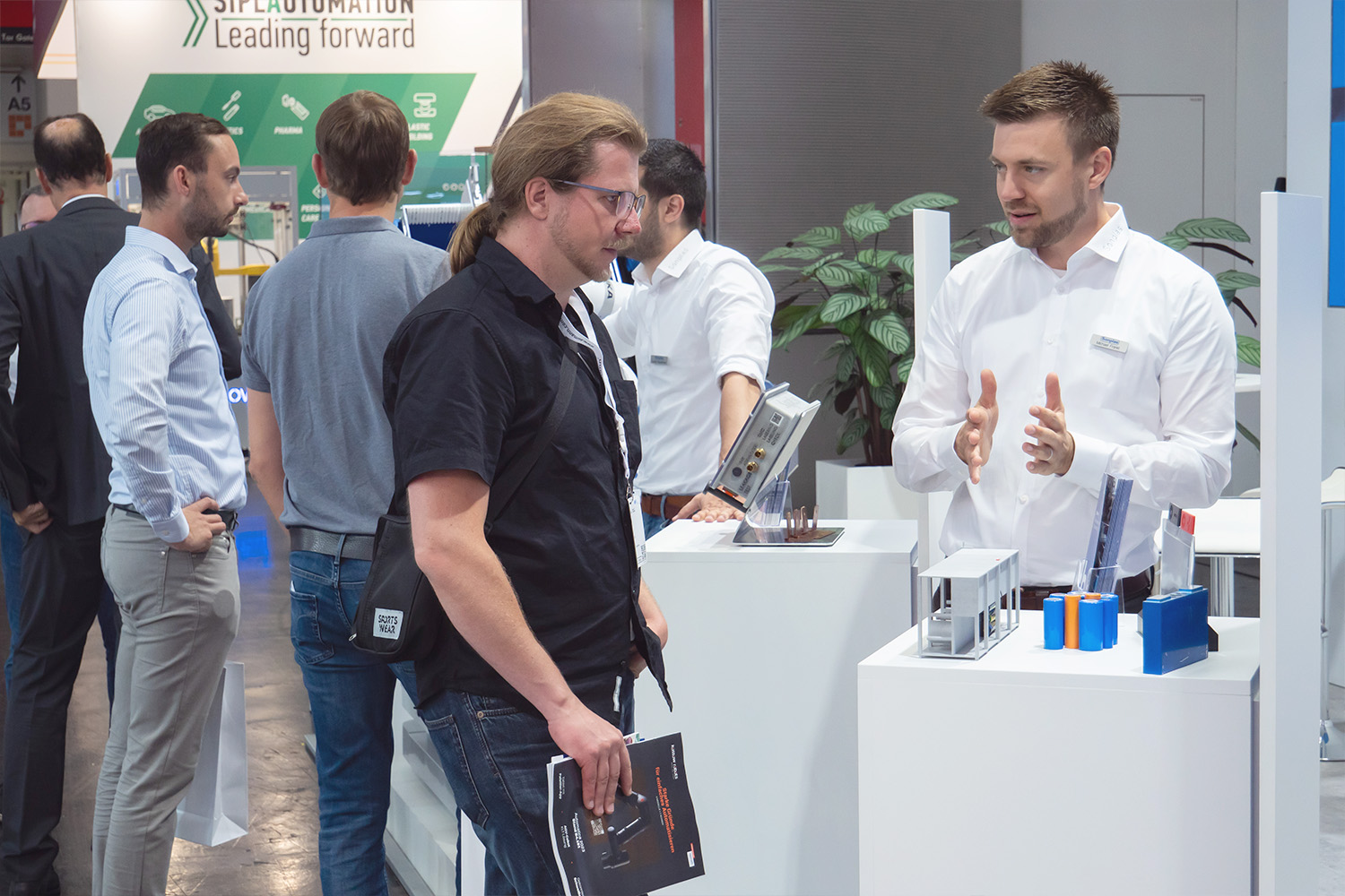 Michael Frankl unterhält sich mit einem Messebesucher am Sonplas-Messestand.